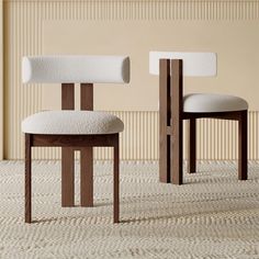 two wooden chairs with white upholstered cushions in front of a beige striped wall