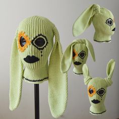 three knitted hats with faces and ears are shown on a mannequin's head