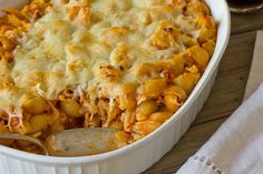 a casserole dish with macaroni and cheese in it on a wooden table