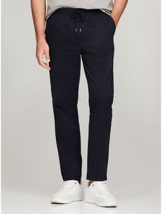 Tommy Hilfiger men's pant. Beyond comfortable, these chinos have an elastic waistband, mastering the dressed-up meets dressed-down pairing. They're cut in a relaxed tapered fit from garment-dyed cotton twill for an ultra-soft feel.  Material: 77% Cotton, 20% Reprocessed Cotton, 3% Elastane. Casual Relaxed Fit Tommy Hilfiger Bottoms, Modern Relaxed Fit Tapered Leg Chinos, Modern Relaxed Fit Tapered Chinos, Cotton Tapered Leg Pants For Casual Gatherings, Spring Pull-on Style Pants, Relaxed Fit Chinos With Tapered Leg And Comfort Waistband, Tommy Hilfiger Tapered Leg Bottoms With Pockets, Tommy Hilfiger Tapered Leg Pants With Pockets, Relaxed Fit Chinos With Elastic Waistband For Elevated Casual