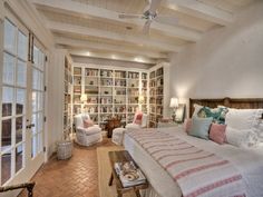 a large bed sitting inside of a bedroom next to a living room filled with furniture