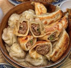 a wooden bowl filled with dumplings and meat