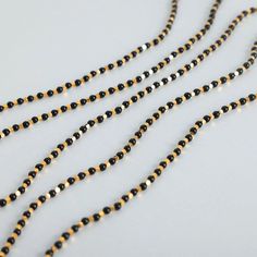 three strands of black and gold beads on a white surface