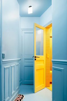 a pair of shoes sitting on the floor in front of an open door with yellow shutters