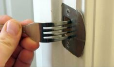 a person is holding a fork in front of a door with an arrow pointing to it