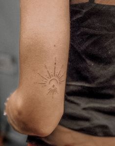 a woman's arm with a tattoo on it that has the sun and stars