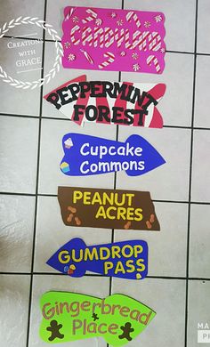 there are many different signs on the floor in front of each other that read peppermin forest, cupcake commonss, peanut acrebs, gumdrop pass