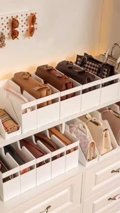 a white shelf filled with lots of purses and handbags on top of drawers