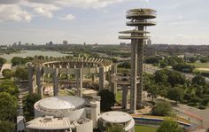 an aerial view of a building with many circular structures and trees in the foreground