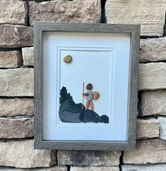 a framed photo of a person sitting on a rock