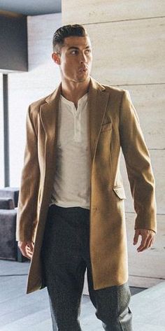 a man in a tan coat is walking