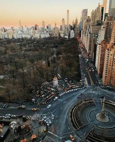 an aerial view of a city with tall buildings and lots of traffic in the foreground