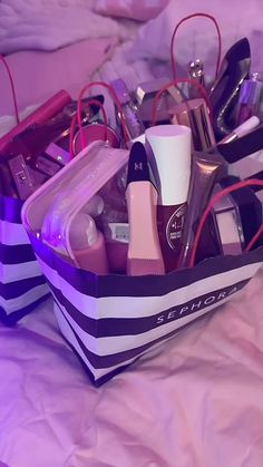 a bag filled with lots of different items on top of a pink sheet covered bed