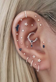 a woman wearing ear piercings with stars and moon designs