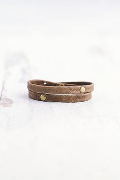 Made for the true warrior, our Double Warrior wrap is a narrow leather bracelet that wraps around the wrist twice and features two flat antique brass rivet accents. **Contents** * Lambskin leather, antique brass hardware * Button clasp closure * Handmade **Care/Import** * Made in the USA **Dimensions** * Adjustable to fit wrist sizes 6.5”-8” | Giving Bracelets Antique Brass Double Warrior Wrap Bracelet at Free People in Grey Adjustable Gold Leather Wrap Bracelet, Adjustable Leather Strap Wrap Bracelet For Everyday, Everyday Double Band Leather Bracelet, Adjustable Vintage Leather Bracelet With Rivets, Vintage Adjustable Leather Bracelet With Rivets, Adjustable Leather Bracelet With Rivets For Gift, Adjustable Leather Bracelet With Rivets, Adjustable Riveted Leather Bracelet Gift, Adjustable Double Band Brown Wrap Bracelet