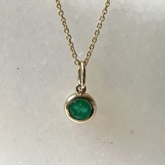 Materials: 14k Gold Gemstone: Genuine Emerald  Total Emerald Carat Weight: 0.26 ct. Pendant Diameter: 11mm x 6mm (including bale) Necklace: Adjustable 16 and 18 inches with a lobster clasp. Chain Weight: 0.6mm 1.35 grams Description: Option for pendant only, necklace available as an add on. The necklace is 16 and 18 inches adjustable, with a lobster clasp at the end. A beautiful round emerald in a bezel setting. Check out our matching bezel emerald earrings in our shop! This beautiful piece will not tarnish in the shower and will not irritate the skin. It will arrive in a jewelry box, with a jewelry bag for traveling. Perfect for gift giving! Feel free to message me with any questions! I will respond within 12 hours. Classic Emerald Pendant Necklace In Bezel Setting, Classic Emerald Pendant Necklace With Bezel Setting, Classic Emerald Necklace In 14k Gold With Bezel Setting, Classic Bezel Set Emerald Pendant Necklace, 14k Gold Emerald Necklace With Bezel Setting For Anniversary, Classic Round Emerald Birthstone Necklace, Classic Round Emerald Necklace, Round Bezel Set Emerald Necklace For May Birthstone, Round Emerald Necklace In 14k Gold Bezel Setting