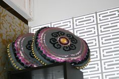 three decorative pillows sitting on top of a shelf