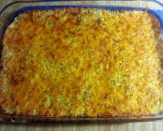 a casserole dish with cheese on top in a blue glass baking pan sitting on a wooden table