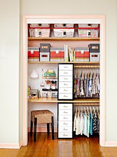 an organized closet with drawers, shelves and clothes hanging on the wall next to a stool