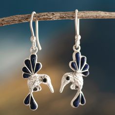 Add a touch of magic to your look with this whimsical set of dangle earrings. Bertha Vera handcrafts them from 950 silver and embellishes each hummingbird with deep blue lapis lazuli gemstones. The Andean artisan draws inspiration from the landscapes and flora of her native Cusco for her pieces. She enjoys the process of shaping local gemstones into high-quality detailed pieces. Luxury Silver Lapis Lazuli Jewelry, Silver Dangle Jewelry With Bird Design, Silver Drop Earrings With Bird Design, Elegant Lapis Lazuli Earrings, Silver Bird Design Drop Earrings, Lapis Earrings Silver, Artisan Hand-strung Lapis Lazuli Jewelry, Silver Lapis Lazuli Dangle Earrings, Large Jewelry