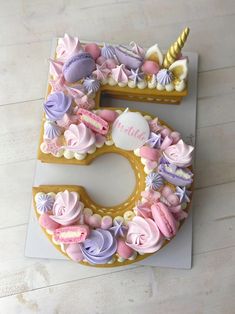 a cake shaped like the number five with pink and purple icing