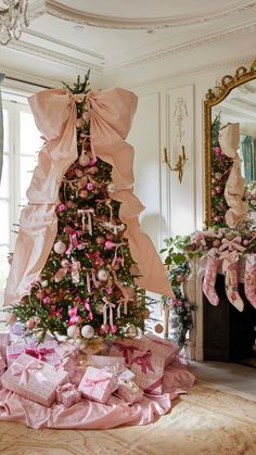 a pink christmas tree with bows and ornaments