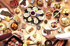 people sitting at a table with plates of food