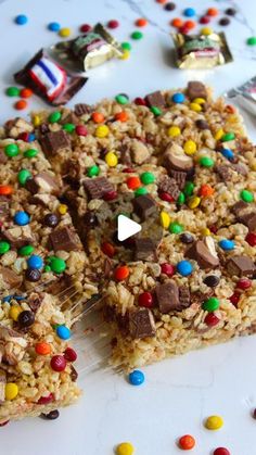 a close up of food on a plate with candy bars and candies around it