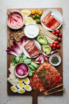 a wooden cutting board topped with lots of food