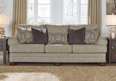 a living room scene with focus on the couch and pillows in front of the window