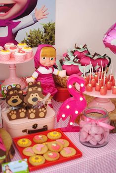 a table topped with lots of desserts and cupcakes on top of it