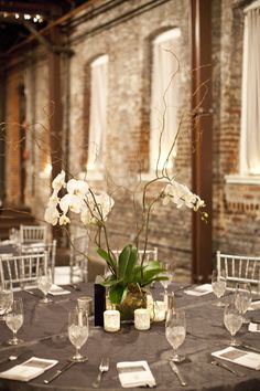 the table is set with white flowers and place settings for guests to sit down at