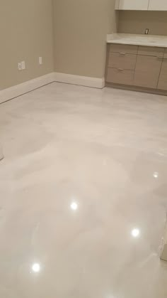 an empty room with white floors and cabinets