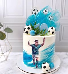 a cake decorated with soccer balls and an image of a man on it