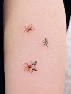 three small flowers on the back of a woman's thigh