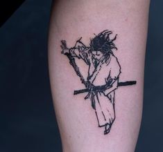 a person with a tattoo on their leg holding a stick and cross in one hand