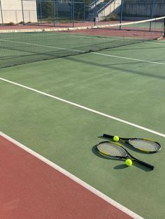 two tennis racquets laying on the court