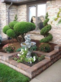 a small garden in front of a brick house