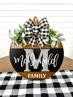 a wooden sign that says the m is for my family on top of a checkered table