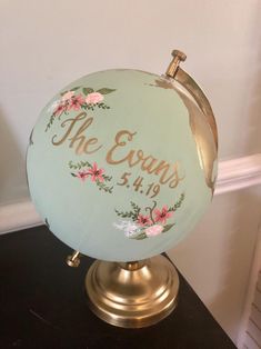 a globe with flowers painted on it sitting on a table