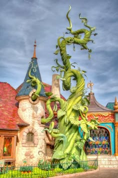 a green dragon statue in front of a building