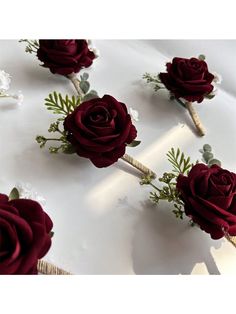 red roses are arranged on a white table cloth