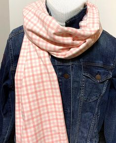 a pink and white checkered scarf on a mannequin