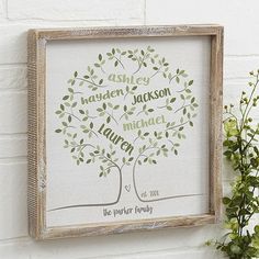 a framed family tree with the names of each member on it and some flowers next to it