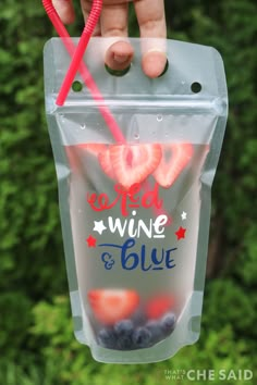 someone holding up a plastic bag with strawberries and blueberries in it that says red wine & blue