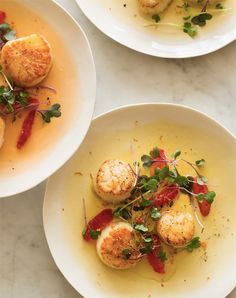 three plates filled with food on top of a white countertop next to each other