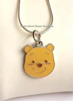 a winnie the pooh necklace on a white surface