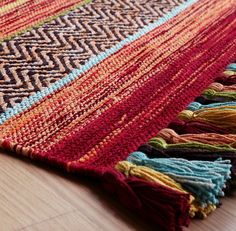 a multicolored rug with fringes on the floor