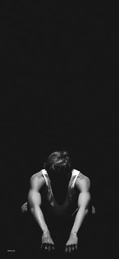 a woman kneeling down in the dark with her hands on her knees