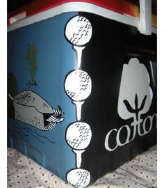 an ice chest is decorated with golf balls and trees on it's sides, along with the word cotton